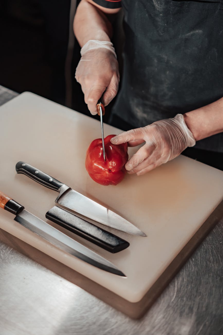 person cutting a capsicum on a chopping board